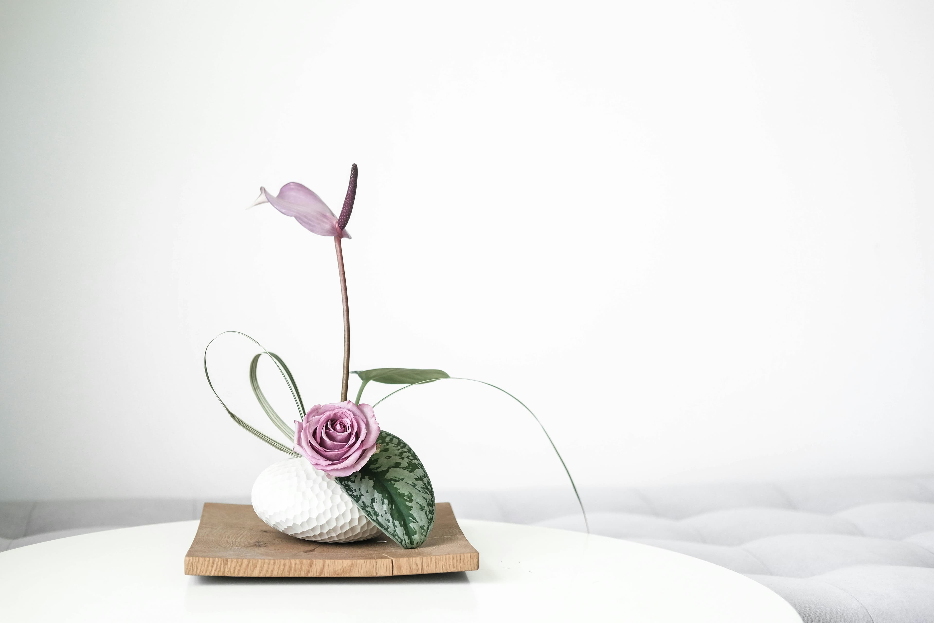 Seasonal flower arrangement in progress on a wooden studio table