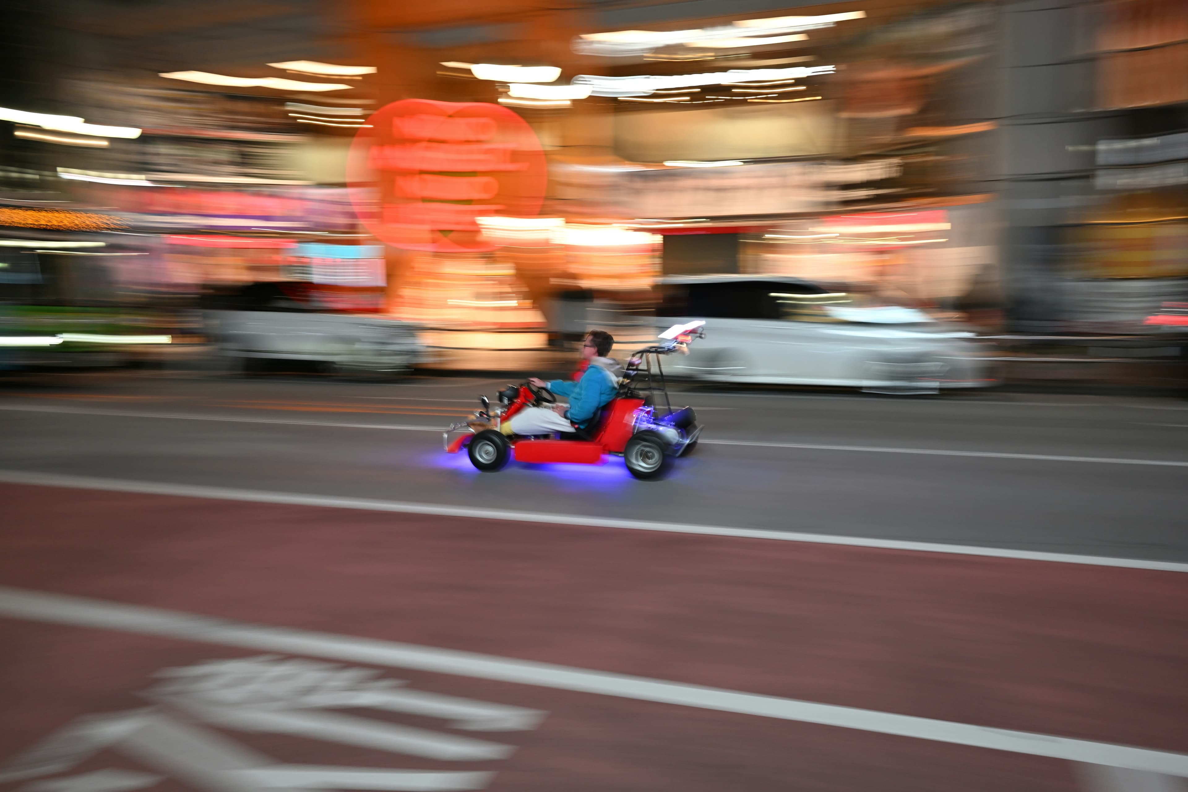Go-kart convoy on a Tokyo boulevard at dusk
