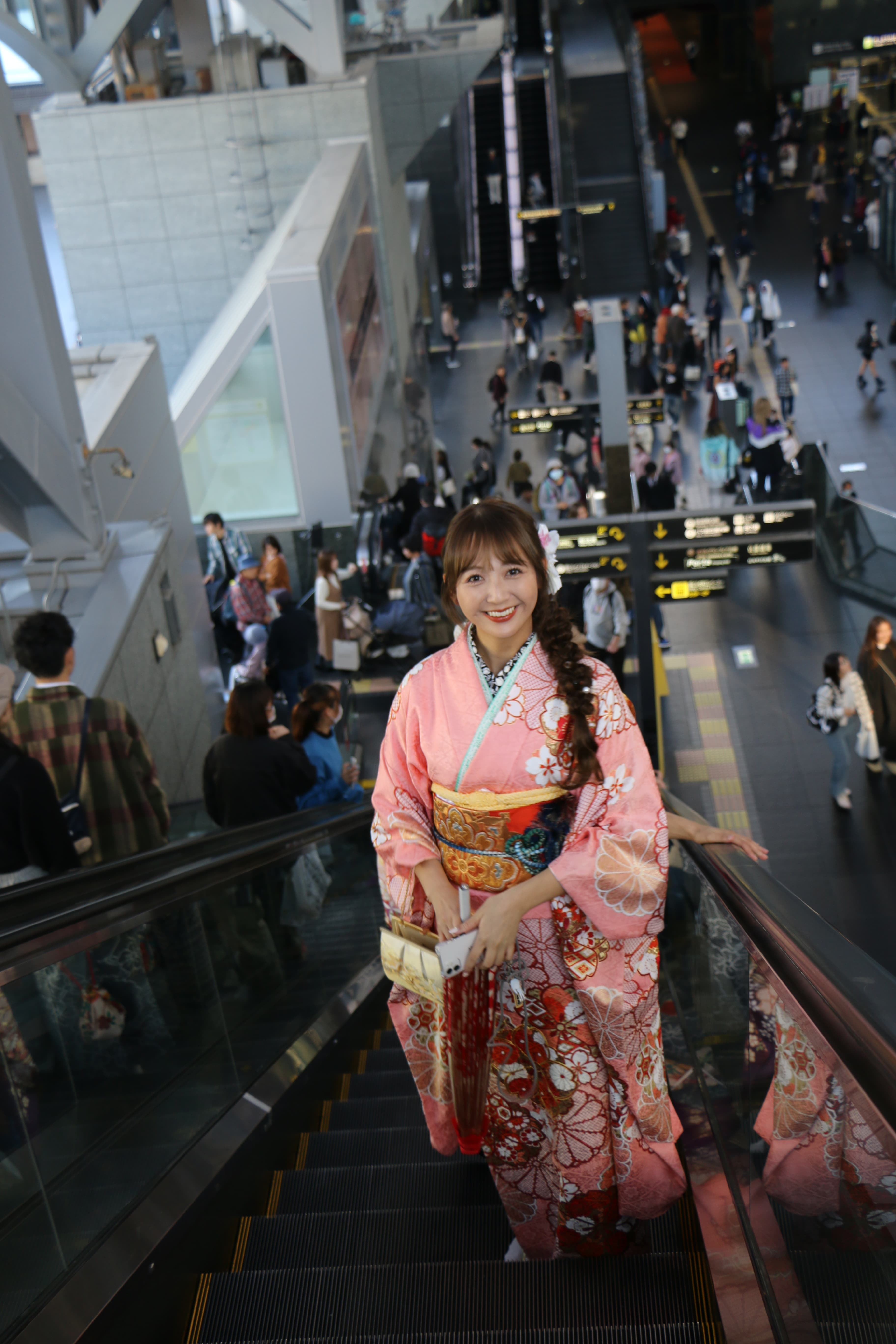 Guest in kimono on a city escalator